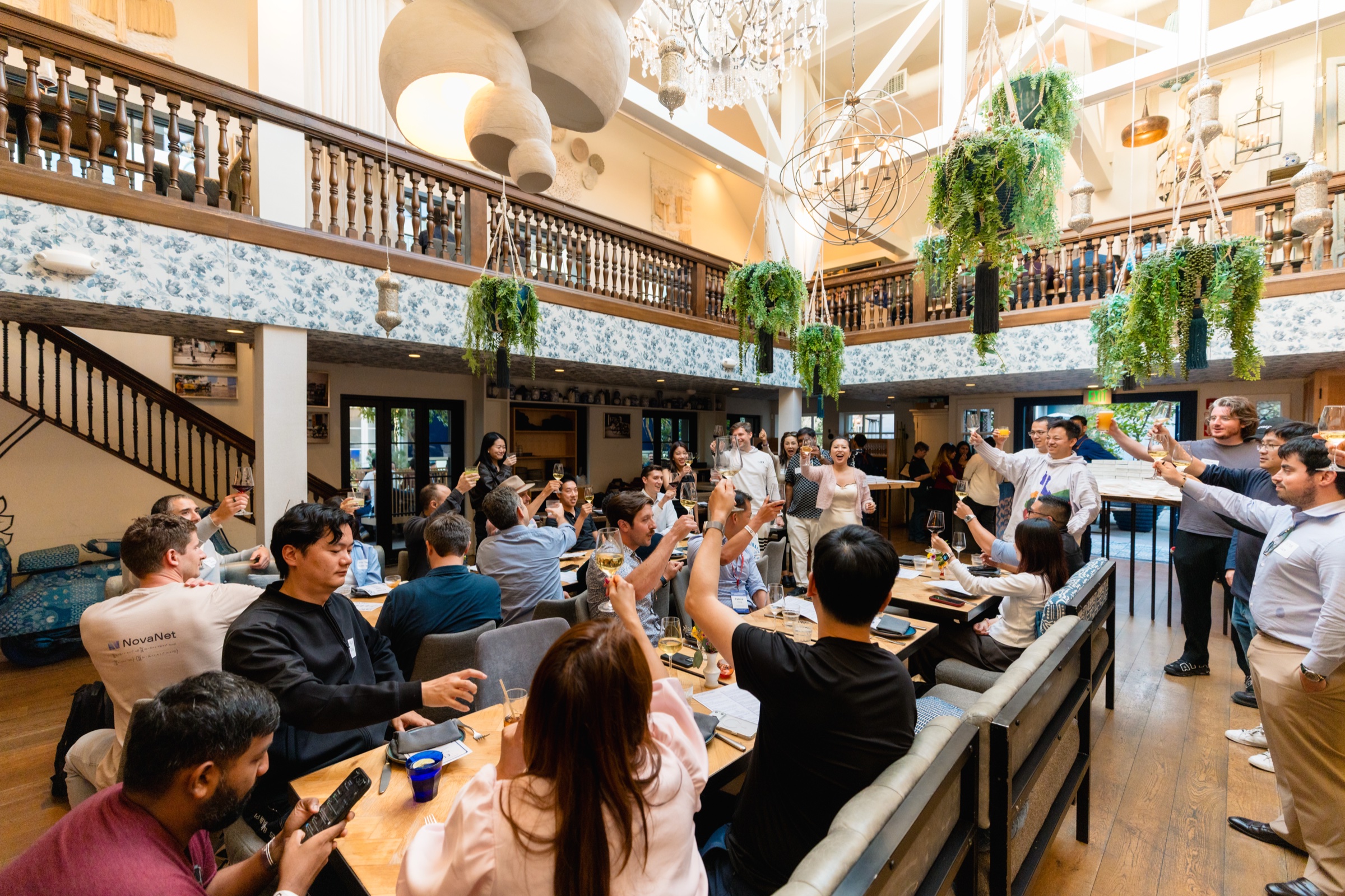 Guests standing and raising glasses in a room-wide toast at the Ettan dinner