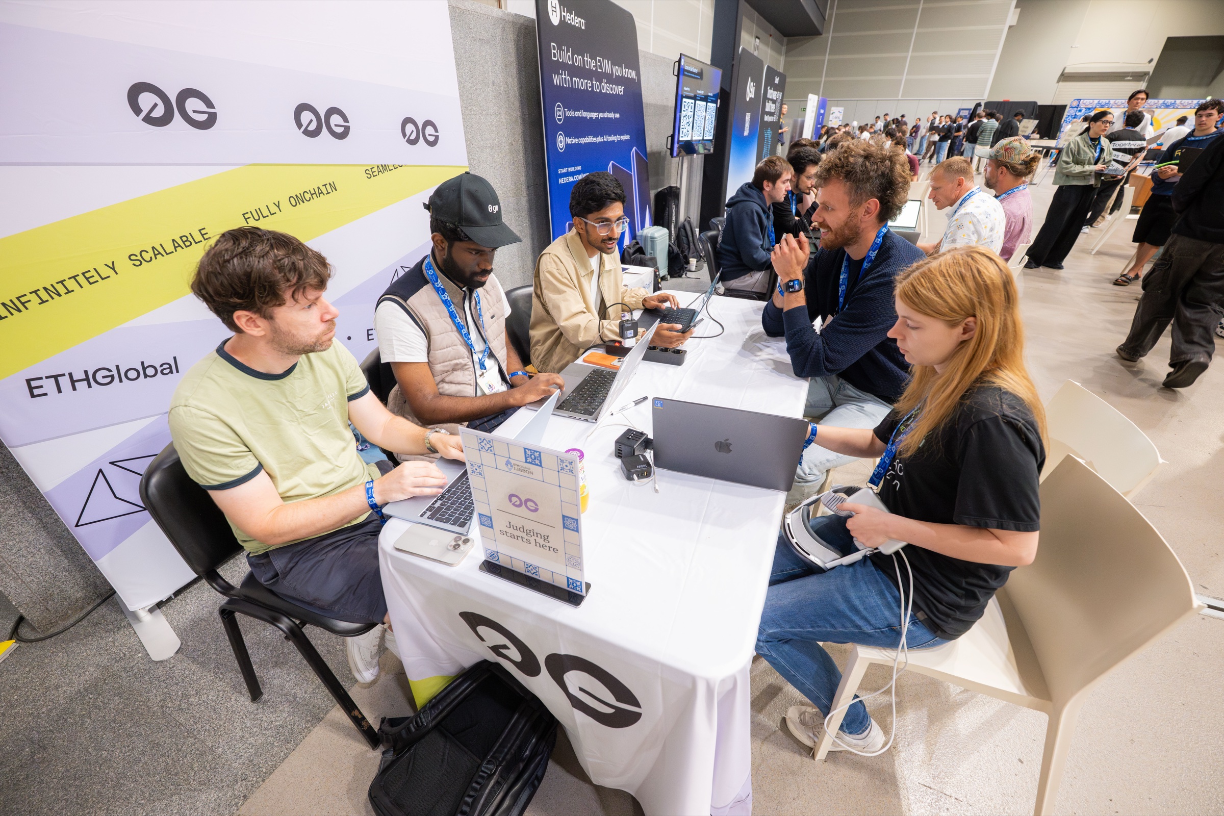 Wide view of the 0G judging table with builders and the expo floor behind